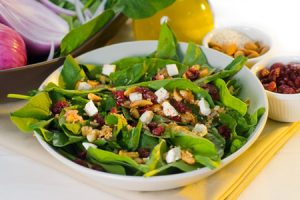 plate of fresh colorfull spinach salad close up